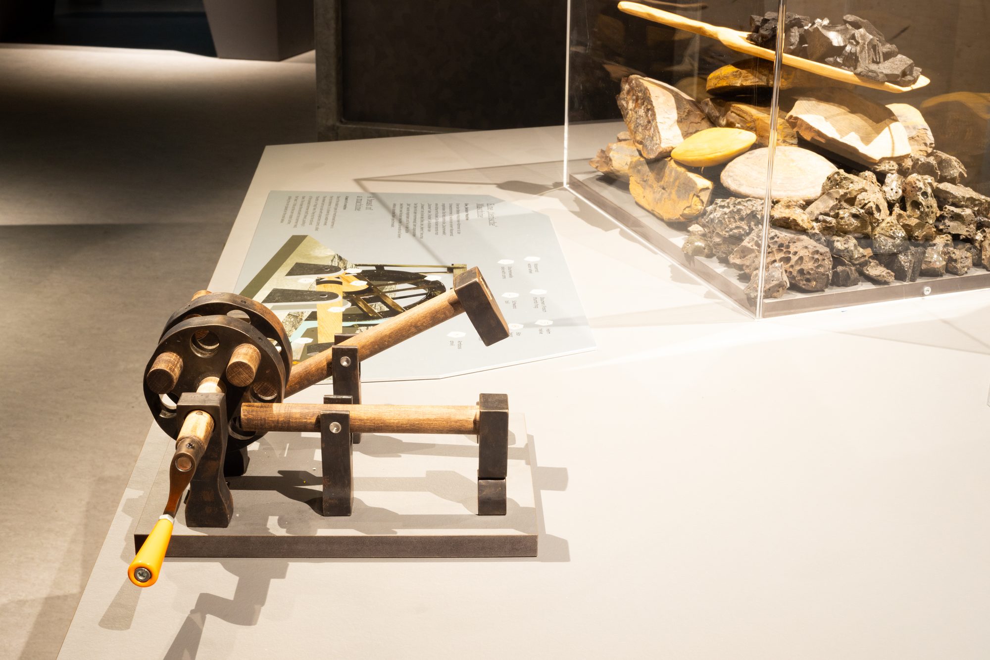 Keltenpark — mechanisches Kurbel-Hammerwerk als Hands-On-Exponat neben einer Fund-Vitrine